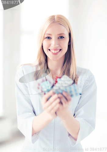 Image of young female doctor with pack of pills