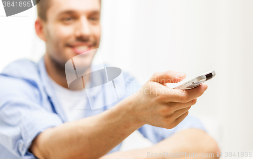 Image of close up of man with tv remote control at home