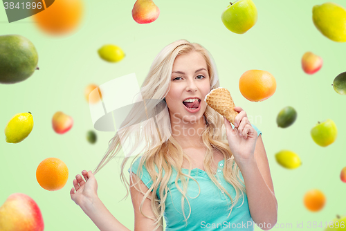 Image of happy young woman in sunglasses eating ice cream