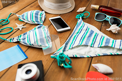 Image of close up of smartphone and beach stuff