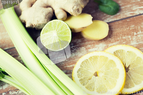 Image of close up of ginger, celery and lemon on table