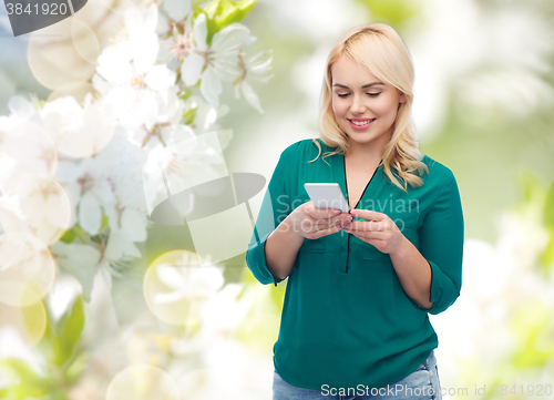 Image of happy woman with smartphone texting message