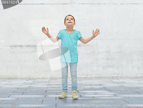 Image of happy little girl looking up to something