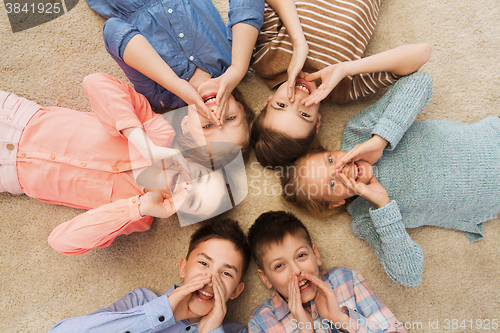 Image of happy smiling children lying on floor in circle