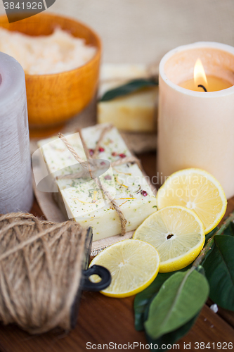 Image of close up of natural soap and candles on wood