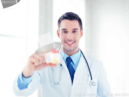 Image of male doctor with jar of capsules