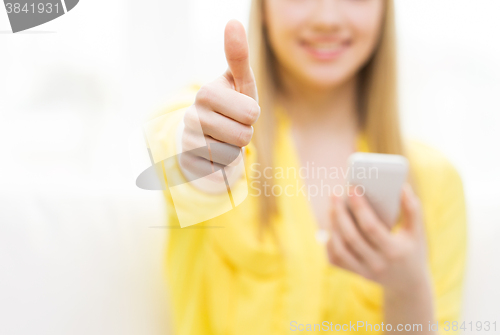 Image of close up of woman with smartphone at home