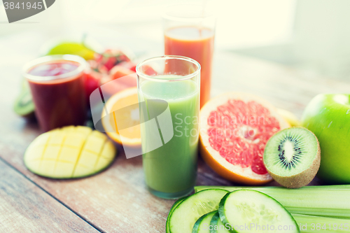 Image of close up of fresh juice glass and fruits on table