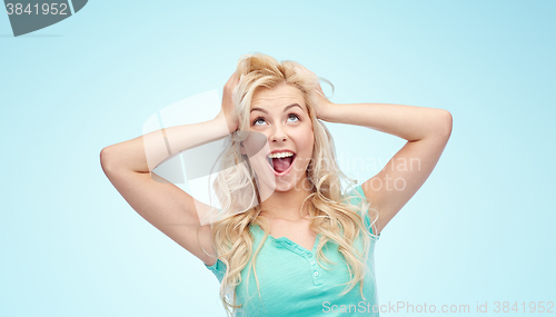 Image of smiling young woman holding to her head or hair