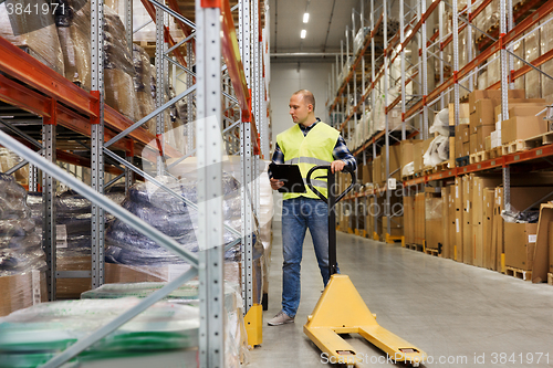 Image of man with loader and clipboard at warehouse