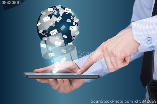 Image of Businessman holding a tablet pc with mobile applications icons on virtual screen . Internet and business concept. message. mail.