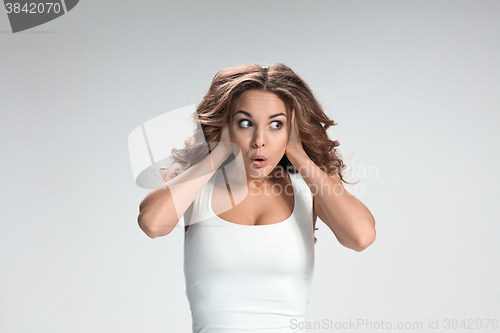 Image of Portrait of young woman with shocked facial expression