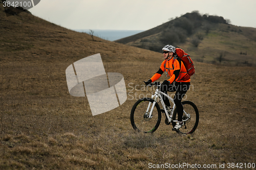 Image of Man cyclist with backpack riding the bicycle