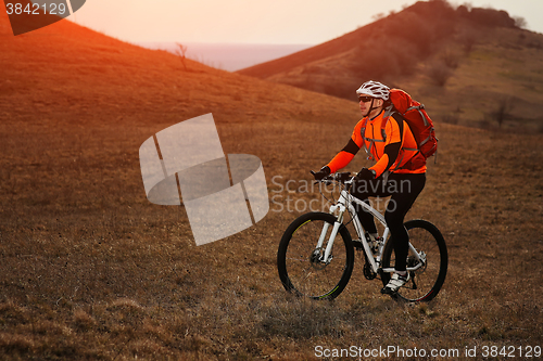 Image of Man cyclist with backpack riding the bicycle