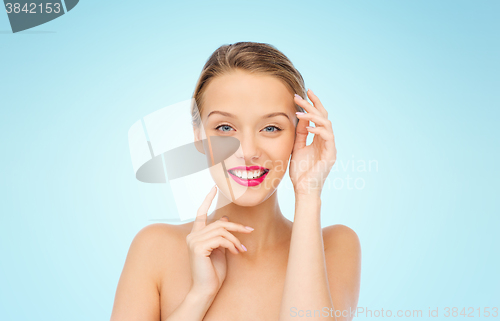 Image of smiling young woman with pink lipstick on lips