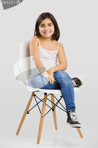 Image of Beautiful young girl sitting on a chair