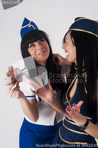 Image of Two pretty funny stewardess with money