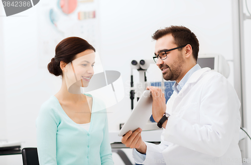 Image of optician with tablet pc and patient at eye clinic