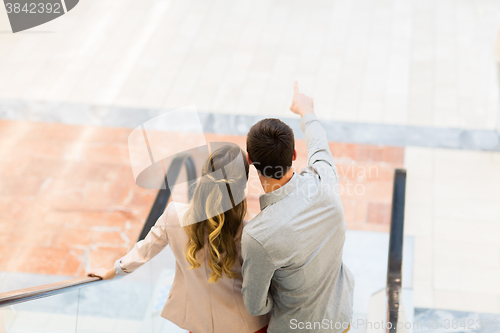 Image of happy young couple with shopping bags in mall