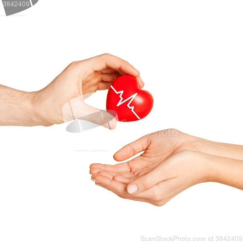 Image of man hand giving red heart to woman