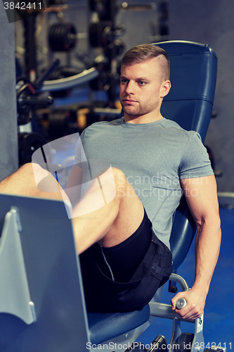 Image of man flexing leg muscles on gym machine