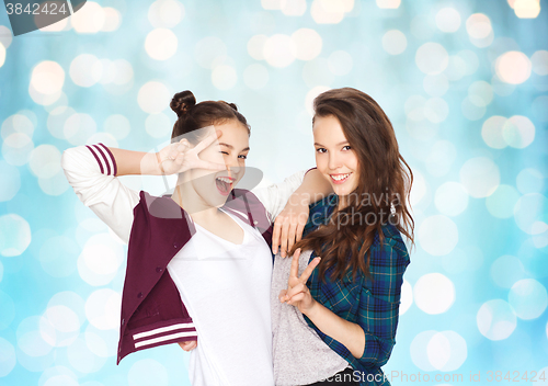 Image of happy pretty teenage girls showing peace hand sign