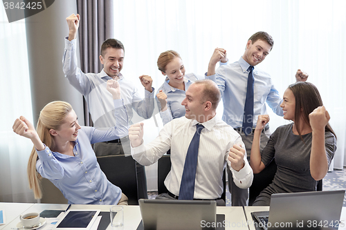 Image of business people celebrating victory in office