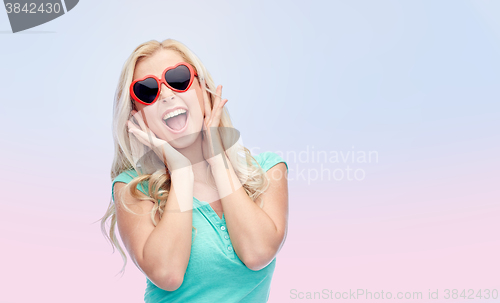 Image of happy young woman in heart shape sunglasses