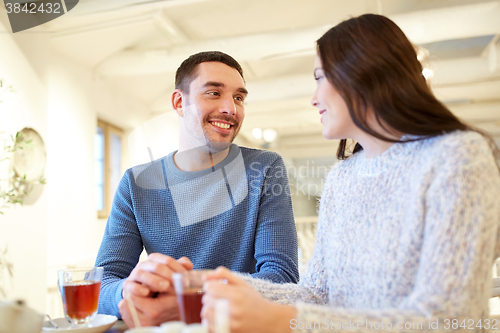 Image of happy couple drinking tea at cafe
