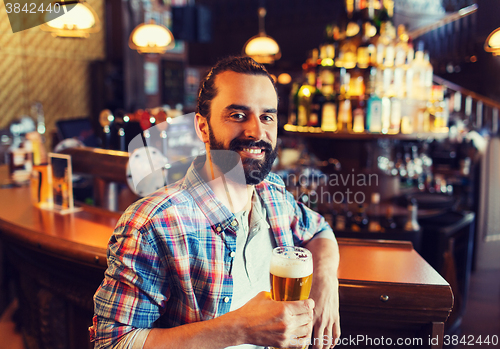 Image of happy man drinking beer at bar or pub