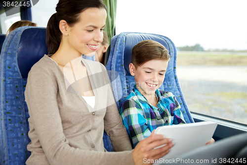 Image of happy family with tablet pc sitting in travel bus