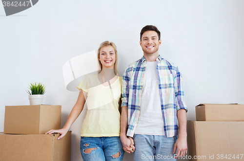Image of smiling couple with big boxes moving to new home