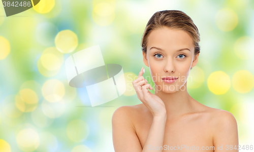 Image of young woman applying cream to her face