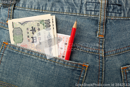 Image of Japanese money and lottery bet slip in pocket