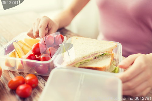 Image of close up of woman with food in plastic container