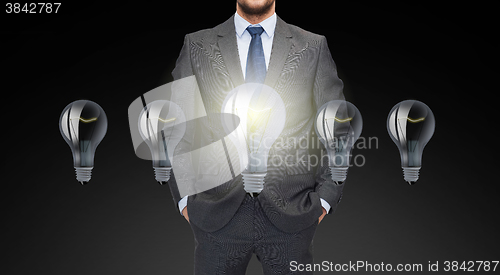 Image of close up of businessman in suit with ligh bulbs