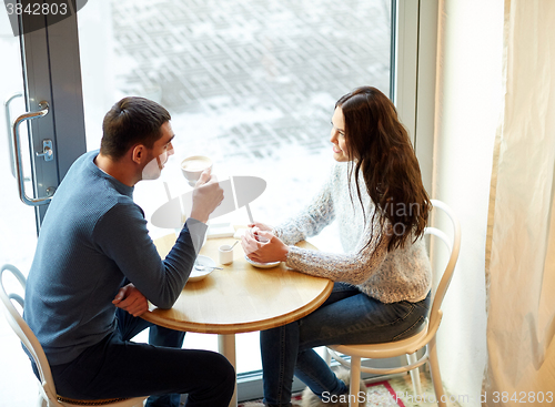 Image of happy couple drinking tea and coffee at cafe