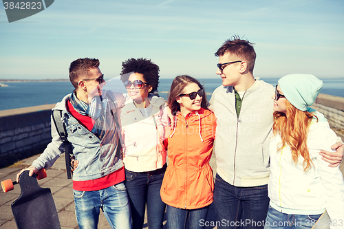 Image of smiling friends in sunglasses laughing on street