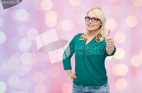 Image of young woman in eyeglasses showing thumbs up