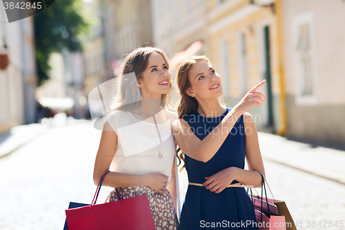 Image of happy women with shopping bags in city