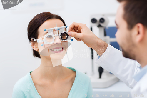 Image of optician with trial frame and patient at clinic