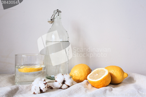 Image of Tasty cool beverage with lemon on white cotton fabric