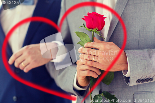 Image of close up of happy male gay couple holding hands