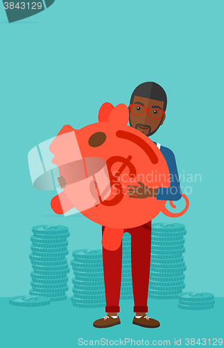 Image of Man carrying piggy bank.