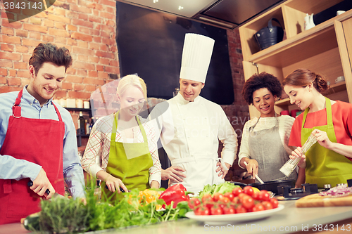 Image of happy friends and chef cook cooking in kitchen