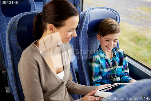 Image of happy family with tablet pc sitting in travel bus