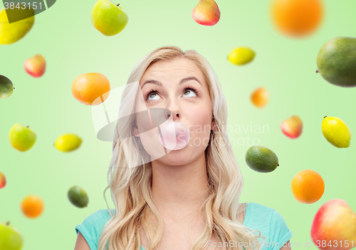 Image of happy young woman or teenage girl chewing gum