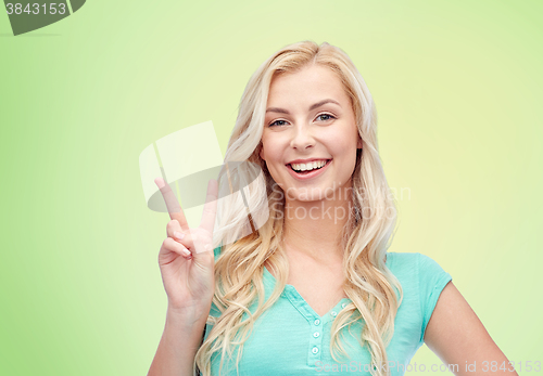 Image of smiling young woman or teenage girl showing peace