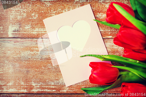 Image of close up of tulips and greeting card with heart