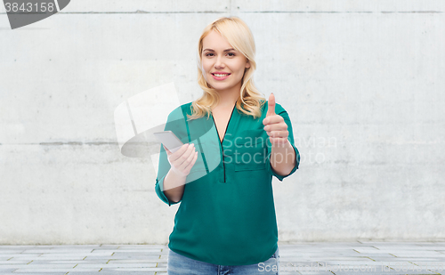 Image of happy woman with smartphone texting message